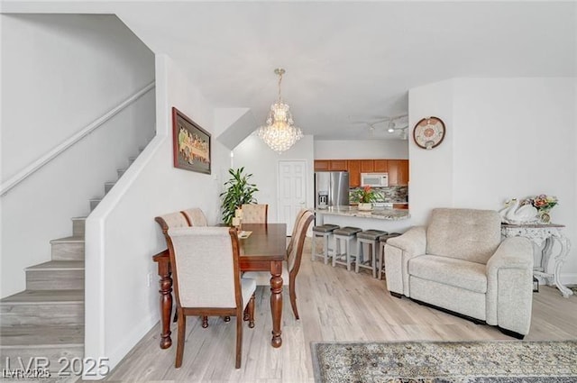 6320 Desert Leaf St Unit 101, North Las Vegas, NV 89081 - dining space featuring stairway, light wood-type flooring, a chandelier, and track lighting