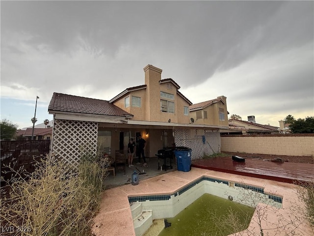 1749 Green Apple Way, Las Vegas, NV 89142 - rear view of property featuring a deck, a fenced backyard, a patio area, and a tiled roof
