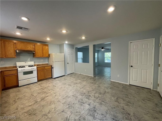 4749 Golden Shimmer Ave, Las Vegas, NV 89139 - kitchen featuring white appliances, brown cabinets, under cabinet range hood, baseboards, and ceiling fan