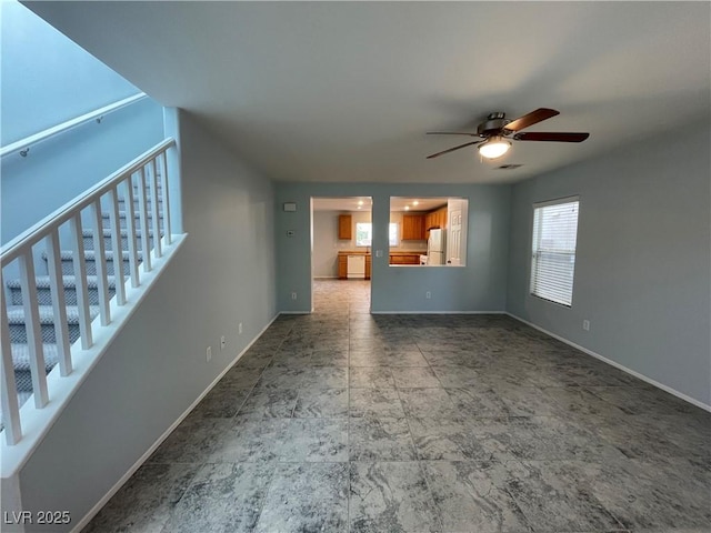 4749 Golden Shimmer Ave, Las Vegas, NV 89139 - unfurnished living room featuring a ceiling fan, baseboards, and stairs
