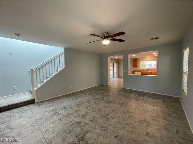 4749 Golden Shimmer Ave, Las Vegas, NV 89139 - unfurnished living room featuring a ceiling fan, stairway, baseboards, and a sink