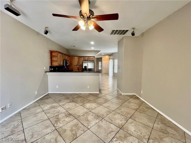 5524 Markley Ave, Las Vegas, NV 89141 - kitchen with stainless steel appliances, light tile patterned floors, dark countertops, a ceiling fan, and a peninsula
