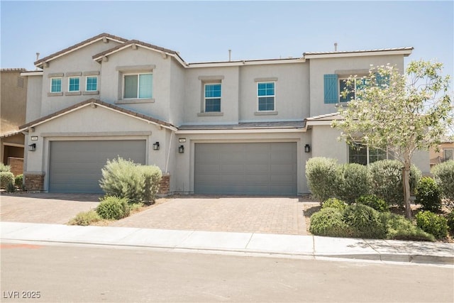 7002 Fossil Rim St, North Las Vegas, NV 89084 - townhome / multi-family property featuring an attached garage, decorative driveway, and stucco siding