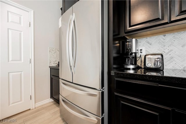 7002 Fossil Rim St, North Las Vegas, NV 89084 - kitchen with freestanding refrigerator, backsplash, baseboards, light wood-type flooring, and dark countertops