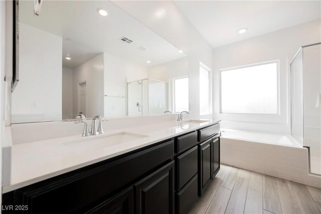 7002 Fossil Rim St, North Las Vegas, NV 89084 - full bath featuring double vanity, a stall shower, a garden tub, recessed lighting, and wood finished floors