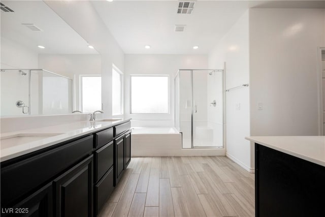 7002 Fossil Rim St, North Las Vegas, NV 89084 - bathroom with a shower stall, a garden tub, wood finished floors, double vanity, and recessed lighting