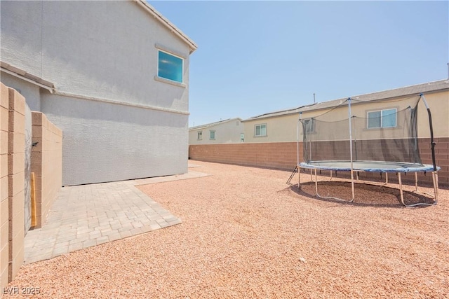 7002 Fossil Rim St, North Las Vegas, NV 89084 - fenced backyard with a trampoline