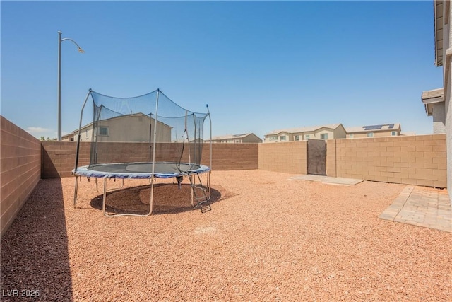 7002 Fossil Rim St, North Las Vegas, NV 89084 - fenced backyard featuring a trampoline