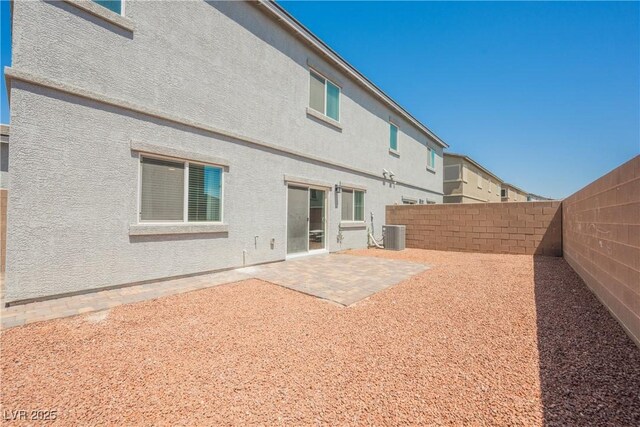 7002 Fossil Rim St, North Las Vegas, NV 89084 - back of property featuring a fenced backyard, a patio, central AC unit, and stucco siding