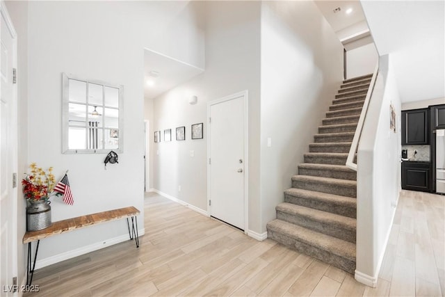 7002 Fossil Rim St, North Las Vegas, NV 89084 - foyer entrance featuring stairway, light wood-style flooring, baseboards, and a towering ceiling