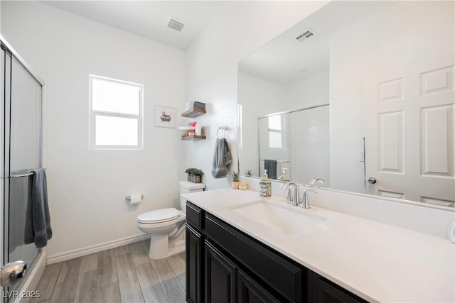 7002 Fossil Rim St, North Las Vegas, NV 89084 - full bath with a shower with shower door, toilet, vanity, baseboards, and wood finished floors