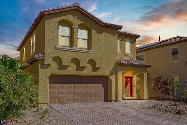 320 Point Loma Ave, North Las Vegas, NV 89031 - mediterranean / spanish home with a tiled roof, a garage, decorative driveway, and stucco siding