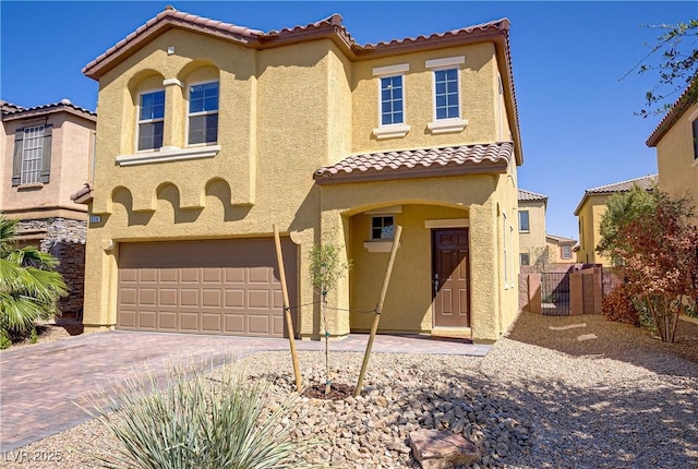 320 Point Loma Ave, North Las Vegas, NV 89031 - mediterranean / spanish-style house featuring a garage, stucco siding, a tiled roof, and decorative driveway