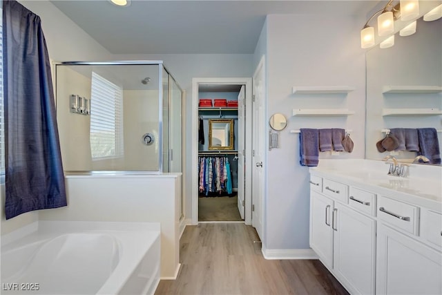 320 Point Loma Ave, North Las Vegas, NV 89031 - full bath featuring a stall shower, wood finished floors, a garden tub, vanity, and a walk in closet