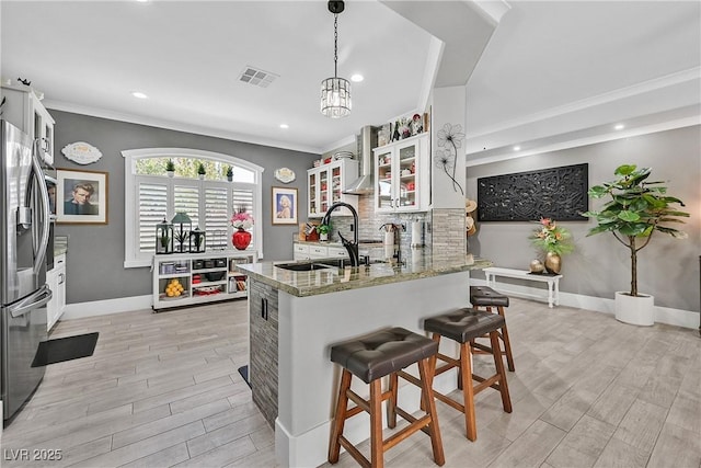 10484 Rose Park Ave, Las Vegas, NV 89135 - kitchen featuring stainless steel fridge with ice dispenser, light wood-type flooring, ornamental molding, a peninsula, and light stone counters