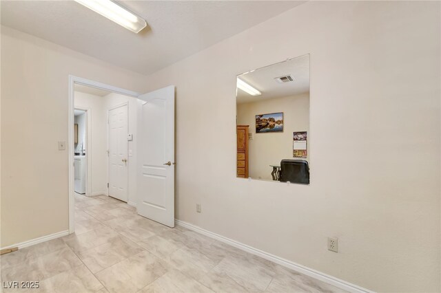 5829 W Patrick Ln, Las Vegas, NV 89118 - unfurnished room featuring baseboards and washer / dryer