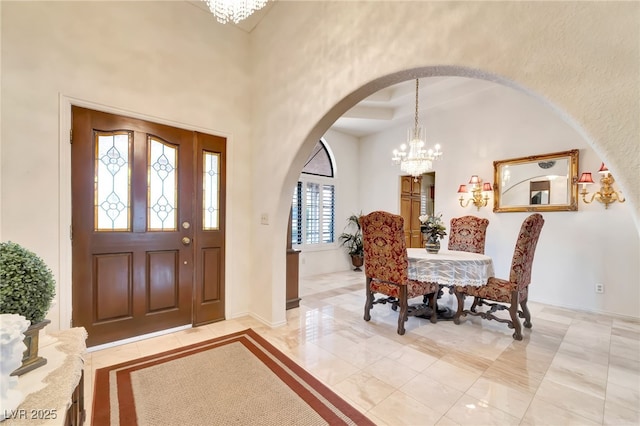 5829 W Patrick Ln, Las Vegas, NV 89118 - foyer featuring arched walkways, a chandelier, a high ceiling, light tile patterned floors, and baseboards