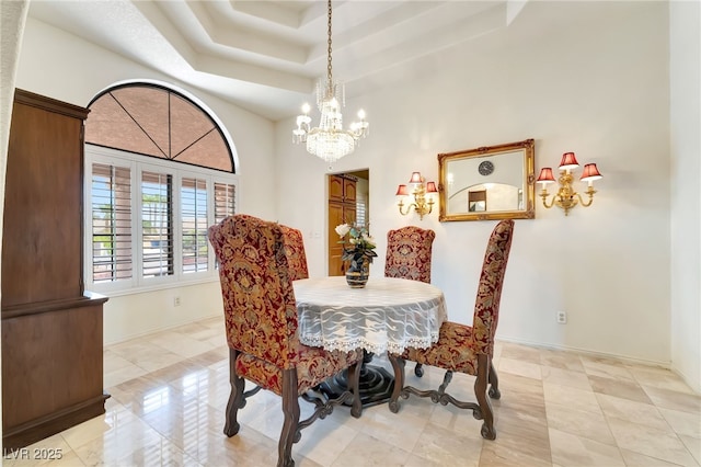 5829 W Patrick Ln, Las Vegas, NV 89118 - dining space featuring a chandelier, a raised ceiling, baseboards, and light tile patterned floors