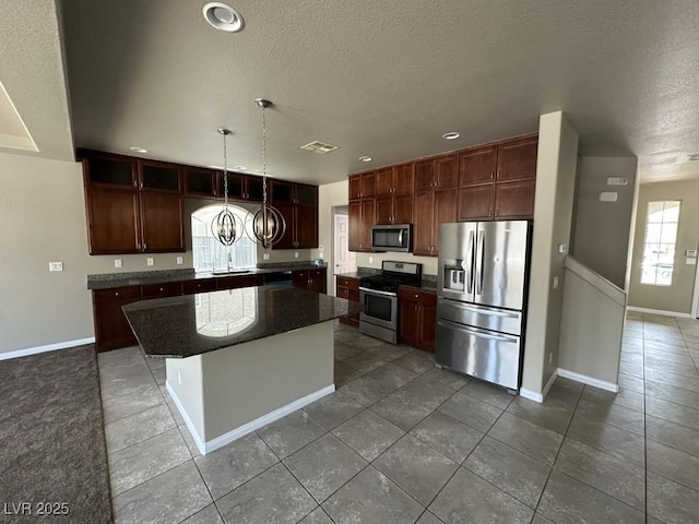 8116 Russell Creek Ct, Las Vegas, NV 89139 - kitchen with appliances with stainless steel finishes, a textured ceiling, baseboards, a center island, and a sink