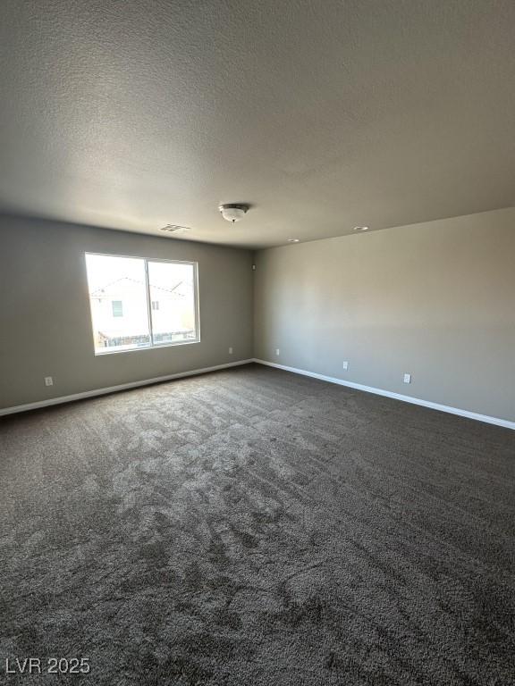 8116 Russell Creek Ct, Las Vegas, NV 89139 - empty room with baseboards, dark carpet, and a textured ceiling