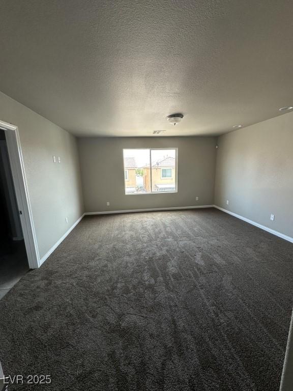8116 Russell Creek Ct, Las Vegas, NV 89139 - empty room featuring dark colored carpet, baseboards, and a textured ceiling