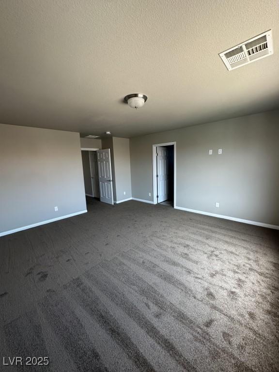 8116 Russell Creek Ct, Las Vegas, NV 89139 - spare room with baseboards, dark carpet, and a textured ceiling