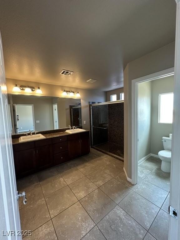 8116 Russell Creek Ct, Las Vegas, NV 89139 - full bathroom featuring double vanity, tile patterned floors, a shower stall, toilet, and baseboards