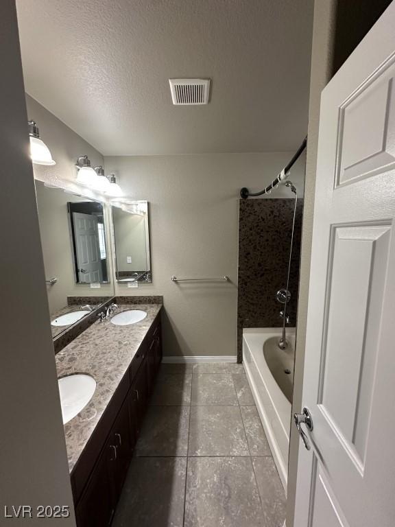 8116 Russell Creek Ct, Las Vegas, NV 89139 - bathroom with double vanity, tile patterned floors, tub / shower combination, a textured ceiling, and baseboards