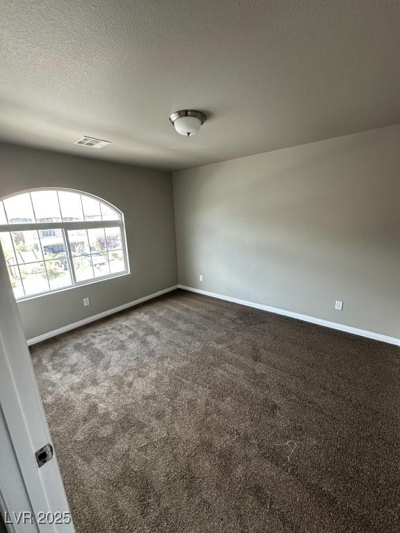 8116 Russell Creek Ct, Las Vegas, NV 89139 - empty room featuring dark carpet, baseboards, and a textured ceiling