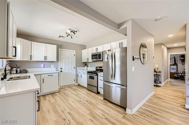 80 E Texas Ave, Henderson, NV 89015 - kitchen with appliances with stainless steel finishes, a sink, light wood-style flooring, light countertops, and baseboards