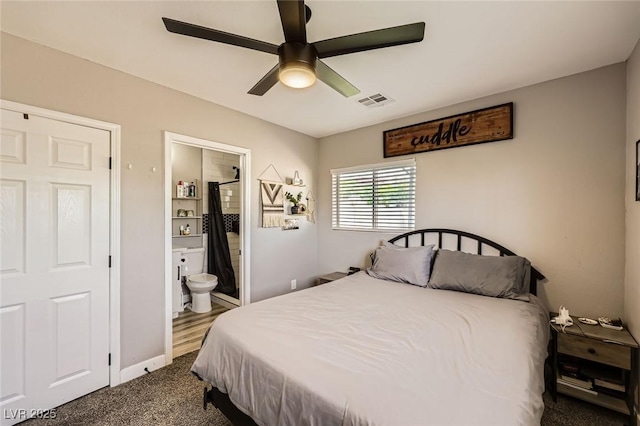 80 E Texas Ave, Henderson, NV 89015 - bedroom featuring ensuite bathroom, dark carpet, ceiling fan, and baseboards