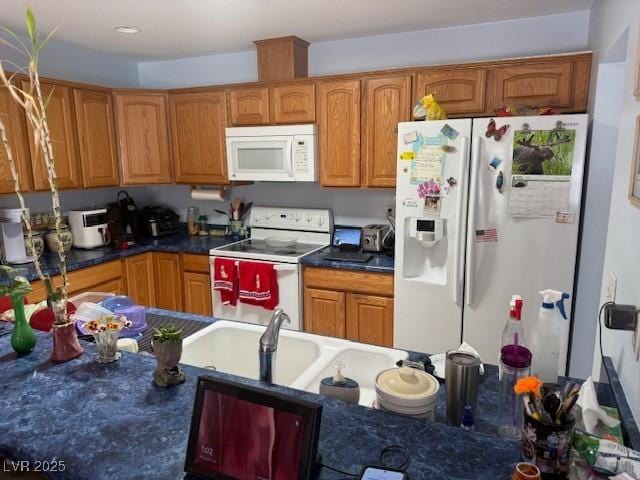 3368 Saddleback Ct, Las Vegas, NV 89121 - kitchen with white appliances, dark countertops, and brown cabinets