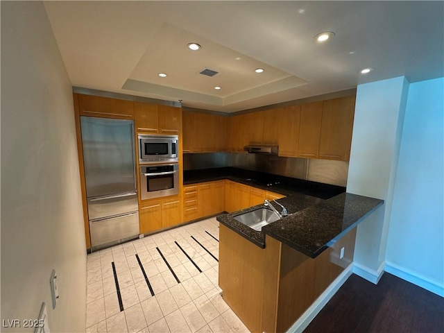 2700 Las Vegas Blvd Unit 2811, Las Vegas, NV 89109 - kitchen featuring built in appliances, a sink, a raised ceiling, a peninsula, and recessed lighting