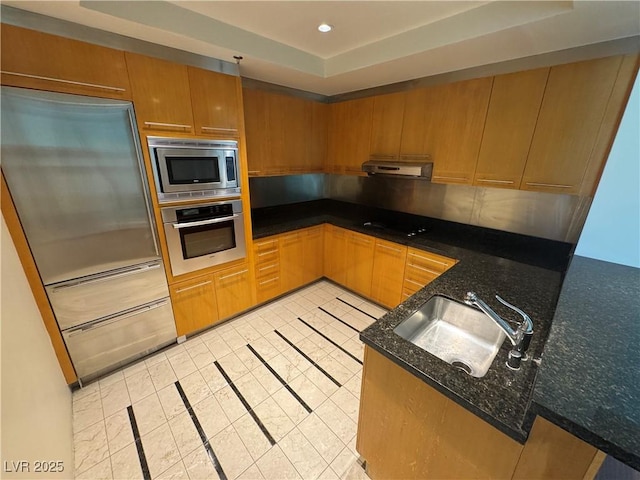 2700 Las Vegas Blvd Unit 2811, Las Vegas, NV 89109 - kitchen with built in appliances, a sink, under cabinet range hood, dark stone counters, and light tile patterned floors