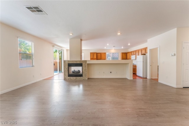 908 Cypress Gold Ct, North Las Vegas, NV 89031 - unfurnished living room featuring light wood-style floors, a multi sided fireplace, baseboards, and recessed lighting