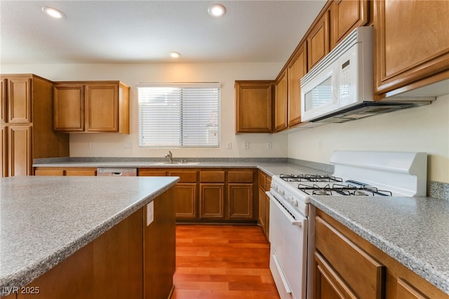 908 Cypress Gold Ct, North Las Vegas, NV 89031 - kitchen featuring white appliances, brown cabinetry, a sink, and recessed lighting