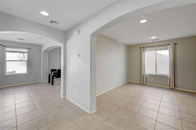 2586 Begonia Valley Ave, Henderson, NV 89074 - empty room with light tile patterned floors, arched walkways, recessed lighting, and baseboards