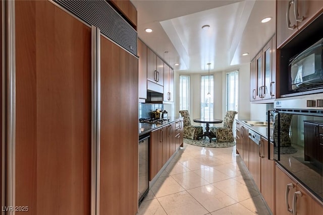 2877 Paradise Rd Unit 906, Las Vegas, NV 89109 - kitchen with modern cabinets, appliances with stainless steel finishes, a raised ceiling, light tile patterned floors, and recessed lighting