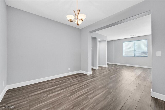 9010 Wine Cellar Ave, Las Vegas, NV 89148 - empty room with dark wood-style floors, a chandelier, and baseboards
