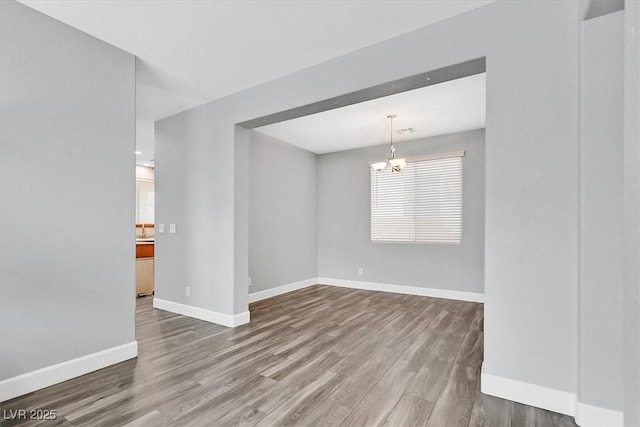 9010 Wine Cellar Ave, Las Vegas, NV 89148 - unfurnished room featuring wood finished floors, baseboards, and a chandelier