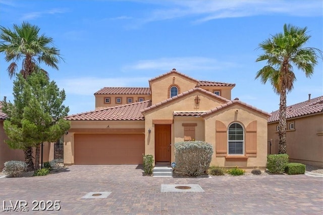 33 Via Di Mello, Henderson, NV 89011 - mediterranean / spanish-style house with stucco siding, an attached garage, a tiled roof, and decorative driveway
