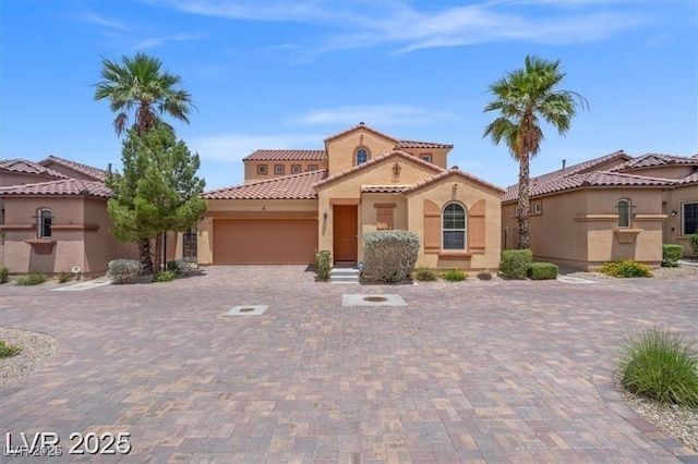33 Via Di Mello, Henderson, NV 89011 - mediterranean / spanish-style house with stucco siding, an attached garage, a tile roof, and decorative driveway