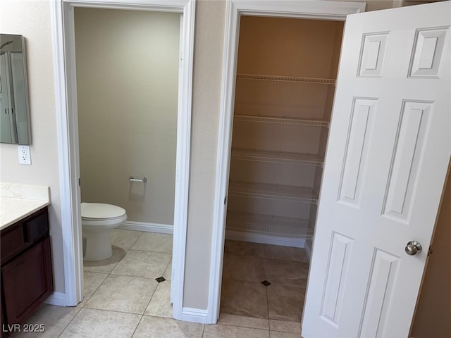 10118 Farmington Hall Ct, Las Vegas, NV 89129 - bathroom with vanity, toilet, tile patterned flooring, and baseboards