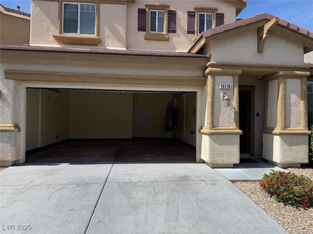 10118 Farmington Hall Ct, Las Vegas, NV 89129 - view of front of property featuring driveway, a garage, water heater, and stucco siding