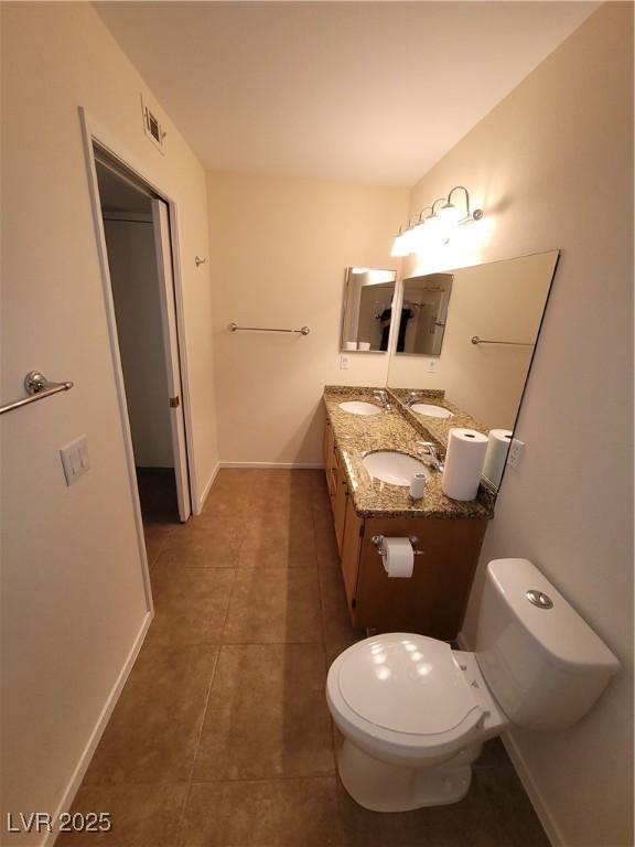 5710 E Tropicana Ave Unit 1172, Las Vegas, NV 89122 - bathroom with tile patterned floors, double vanity, toilet, and baseboards