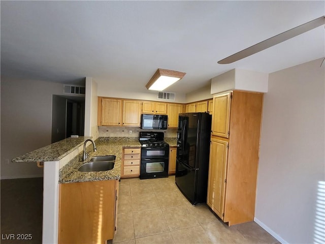 5710 E Tropicana Ave Unit 1172, Las Vegas, NV 89122 - kitchen with black appliances, a sink, a peninsula, stone counters, and light tile patterned floors