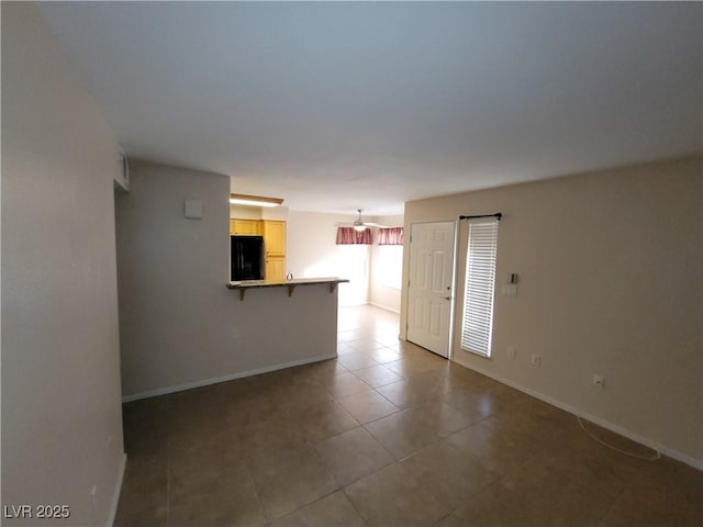 5710 E Tropicana Ave Unit 1172, Las Vegas, NV 89122 - unfurnished living room with baseboards and tile patterned flooring