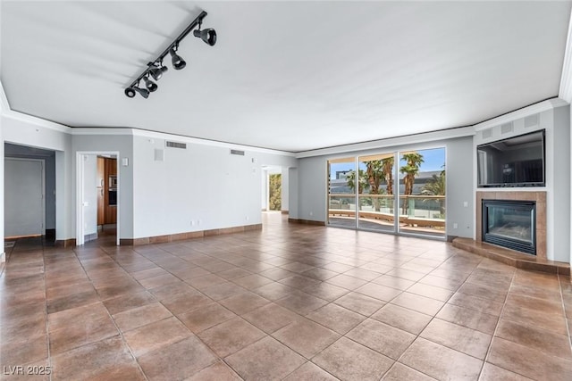 2857 Paradise Rd Unit 301, Las Vegas, NV 89109 - unfurnished living room featuring ornamental molding, a fireplace, baseboards, and tile patterned flooring