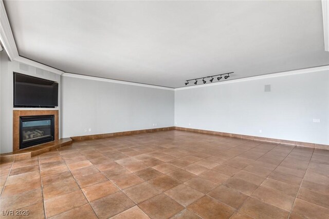 2857 Paradise Rd Unit 301, Las Vegas, NV 89109 - empty room with ornamental molding, rail lighting, a tiled fireplace, and baseboards