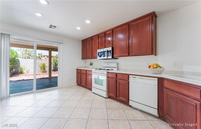 8872 Perfect Diamond Ct, Las Vegas, NV 89129 - kitchen with white appliances, light countertops, recessed lighting, light tile patterned flooring, and reddish brown cabinets